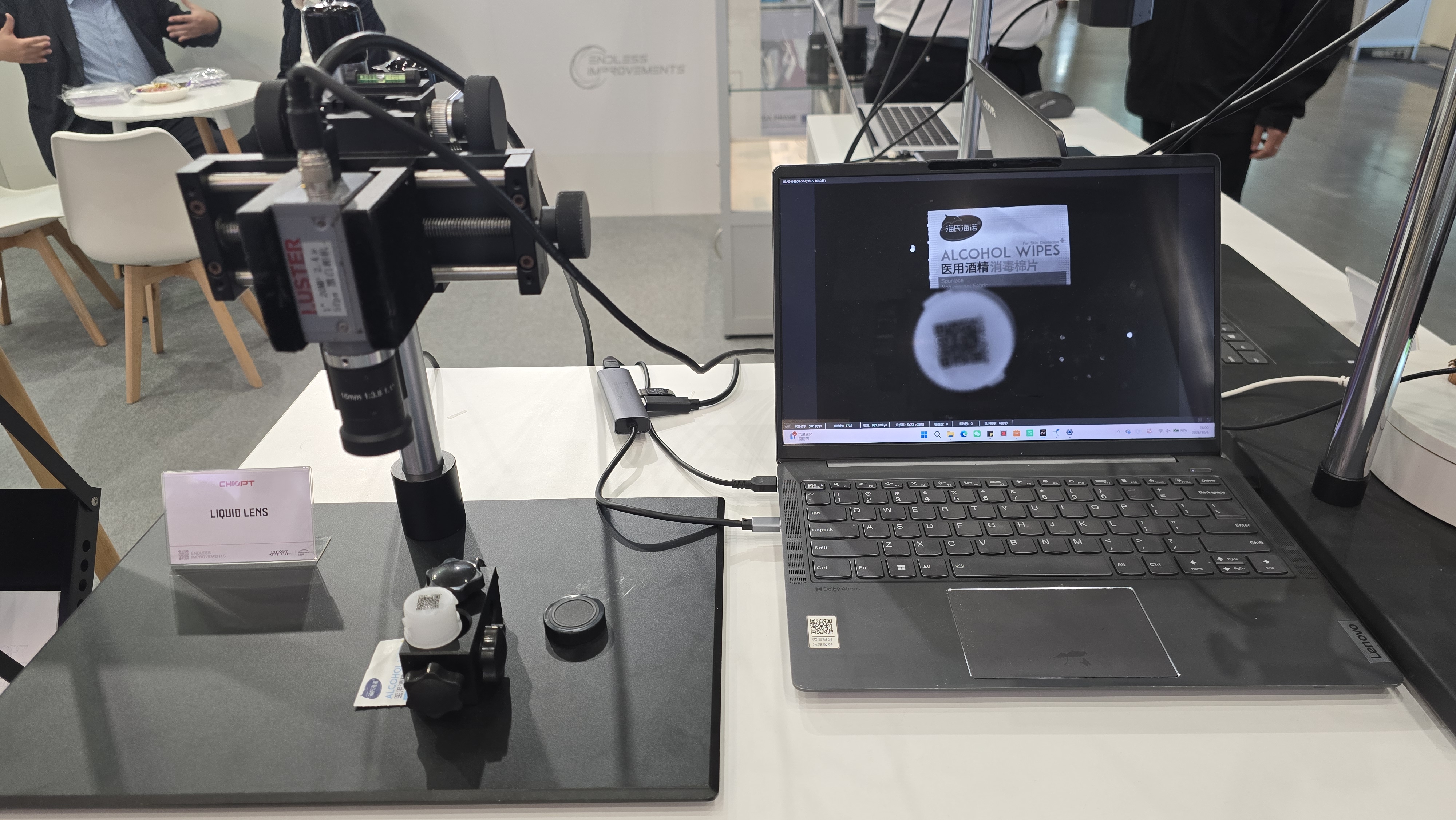 Live liquid lens demonstration at the CHIOPT booth, with magnified imaging shown on a laptop screen